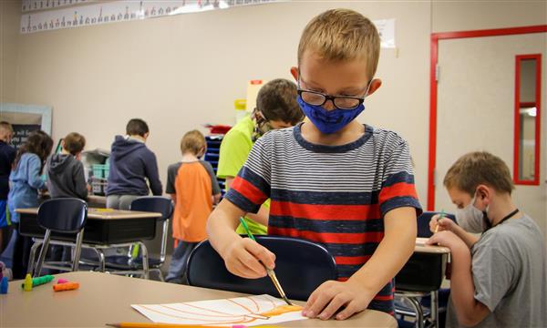 Boy works on pumpkin drawing
